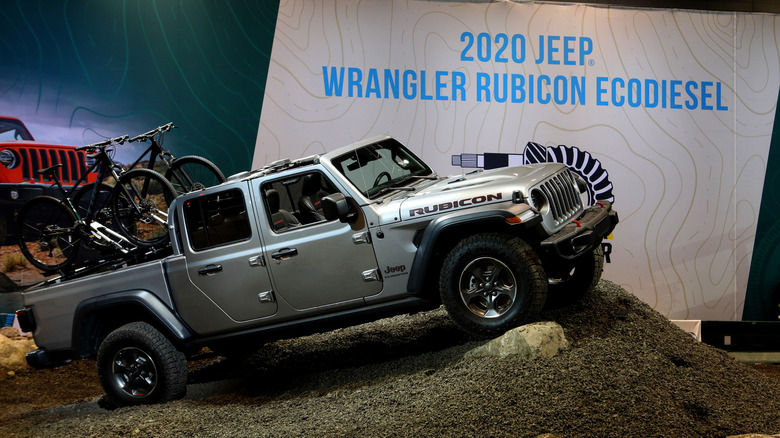 2020 Jeep Dadeiator Ecodiesel의 측면 프로파일 샷은 먼지 언덕 위에 전시되어 있습니다.