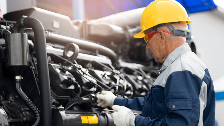 디젤 엔진에서 작업하는 태블릿 컴퓨터가있는 기계공