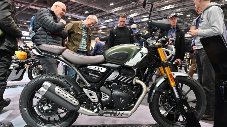 Triumph Scrambler 400 x 오토바이를 전시하는 남성