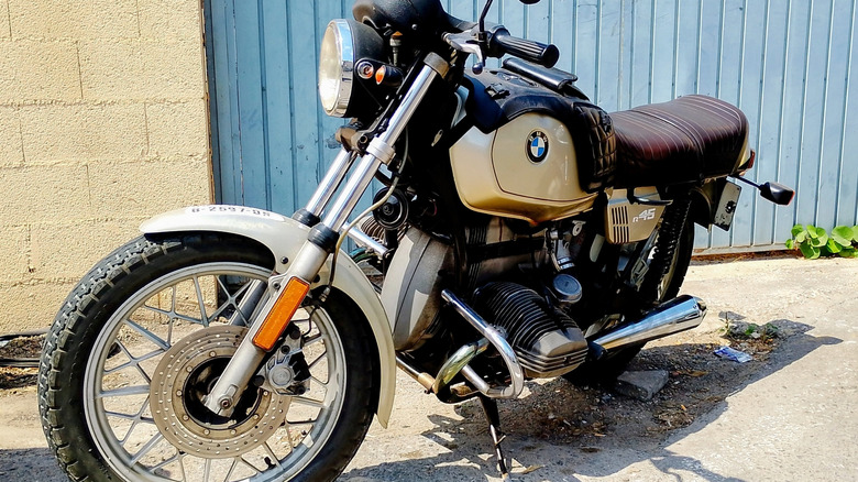 BMW R45 스크램블러 자전거는 햇볕이 잘 드는 차도에 주차되었습니다