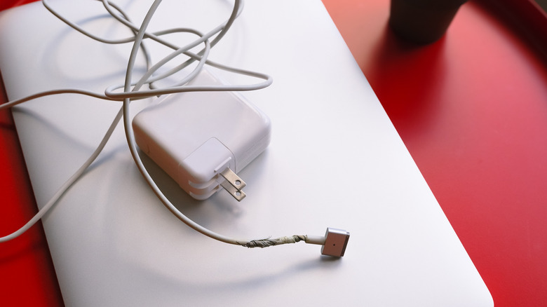 포트 근처에 꼬인 케이블이있는 노트북 충전기