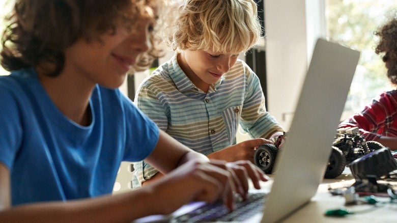 노트북에 중학생 소년, RC 자동차를 가진 다른 바이올린