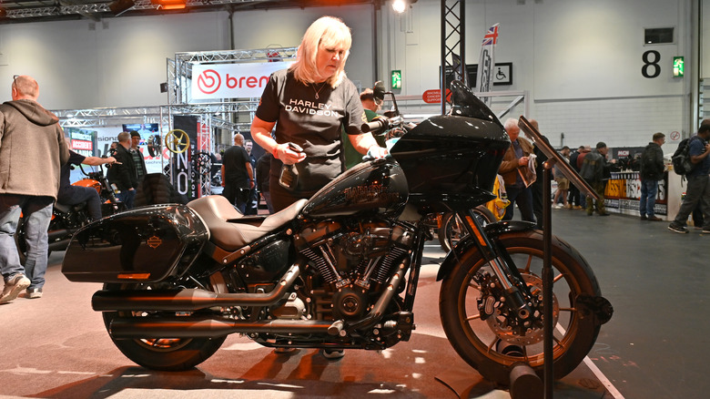 검은 셔츠를 입은 여자, 새로운 할리 데이비슨 오토바이를 확인