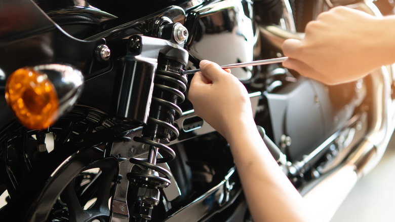 오토바이에서 후방 충격을 수리하는 손