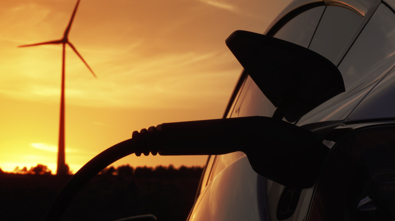 백그라운드에 풍차를 가진 EV 충전기