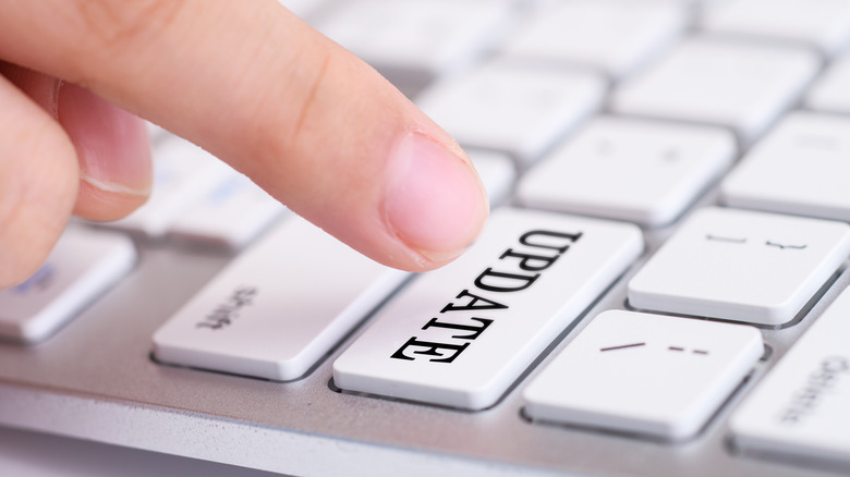 흰색 키보드에서 업데이트라는 버튼을 누르는 손가락