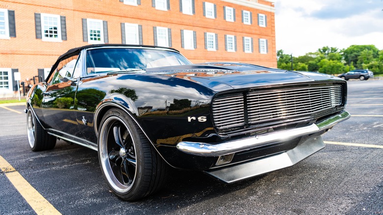 벽돌 건물 앞 주차장에서 검은 색 1967 Chevrolet Camaro SS의 낮은 정면보기