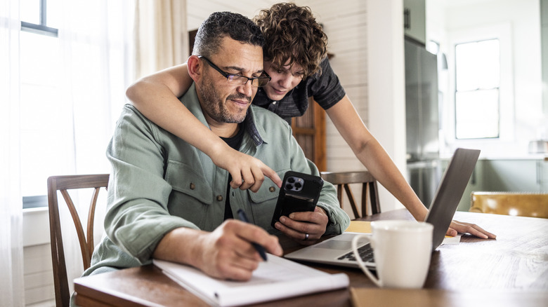 나이든 남자를 보여주는 아이는 아이폰을 사용하는 방법을 보여줍니다