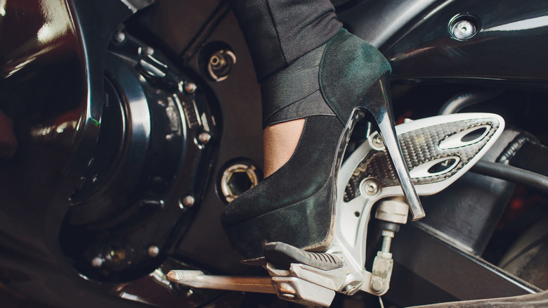 오토바이 킥 스타트 레버에 높은 굽 신발을 신는 발