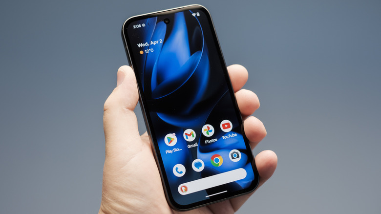 새로운 Google Pixel 9A Android 스마트 폰이 손으로 잡고 홈 화면을 보여줍니다.