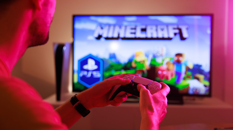 컨트롤러로 텔레비전에서 마인 크래프트를하는 남자