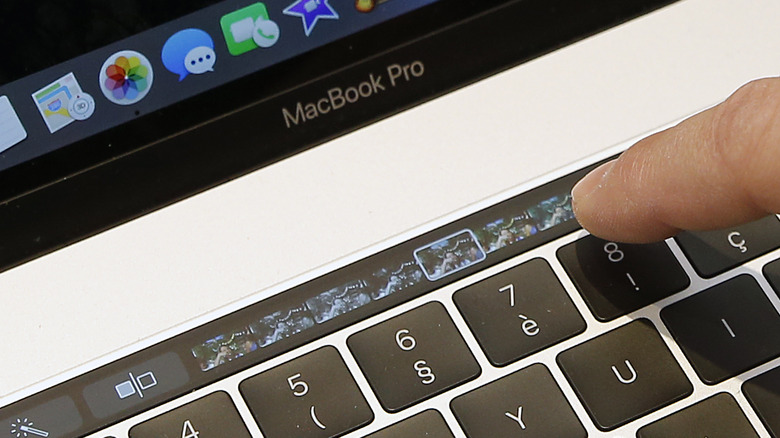 MacBook Pro Touch Bar와 상호 작용하는 사람.