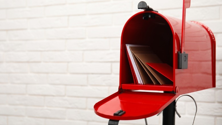 안에 편지가 들어 있는 열린 빨간색 우체통