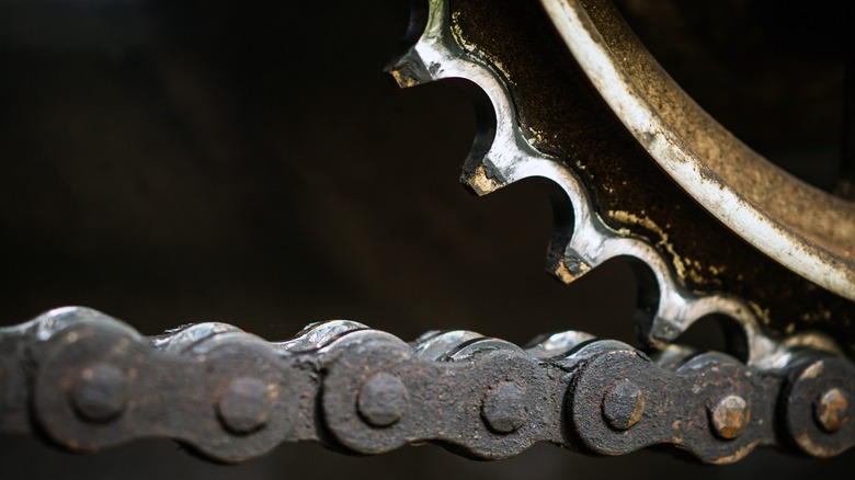 더러운 오토바이 체인과 마모된 스프로킷