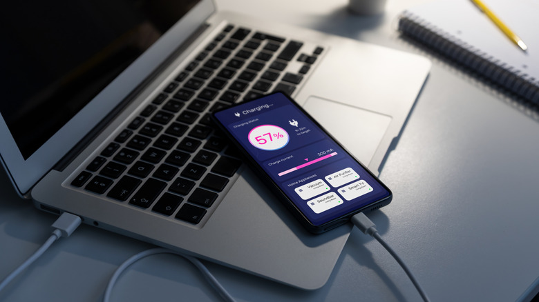 휴대폰이 노트북에 연결되어 충전 중입니다.