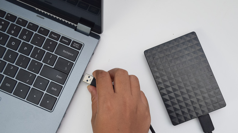 외부 하드 드라이브를 노트북에 연결하는 사람.