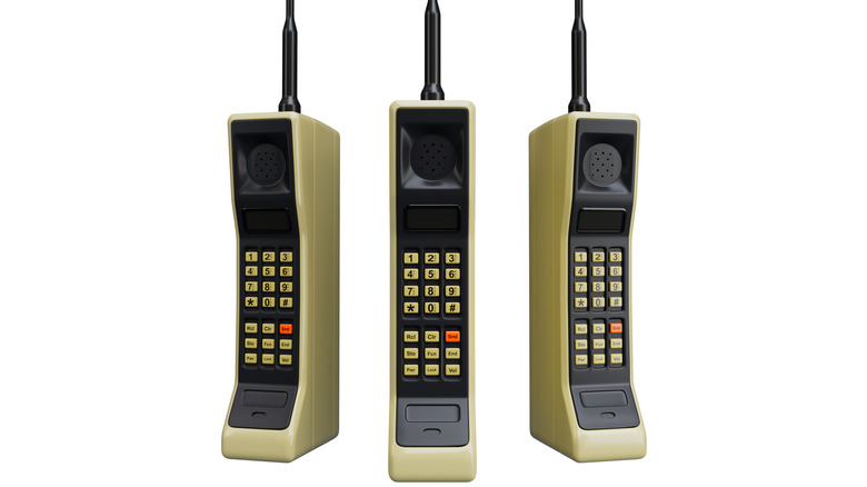 숫자 패드가 카메라를 향하고 나란히 놓인 3대의 Motorola DynaTAC 휴대폰
