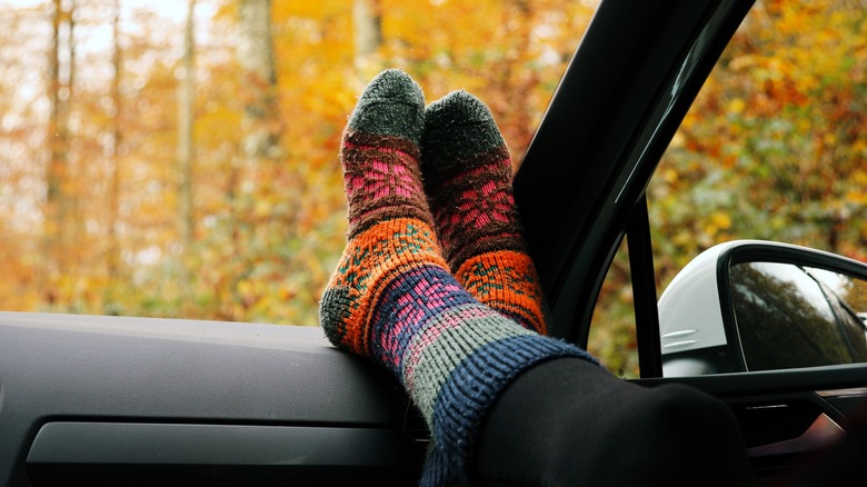 대시보드 위에서 양말을 신은 발을 차는 승객