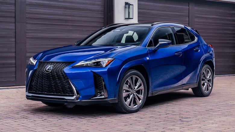 집 앞에 주차된 파란색 2026 Lexus UX.