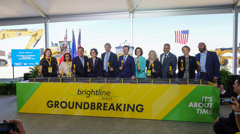 네바다에서 열린 Brightline West 기공식의 배너 뒤에 있는 Pete Buttigieg 전 교통부 장관을 포함한 관리 패널.