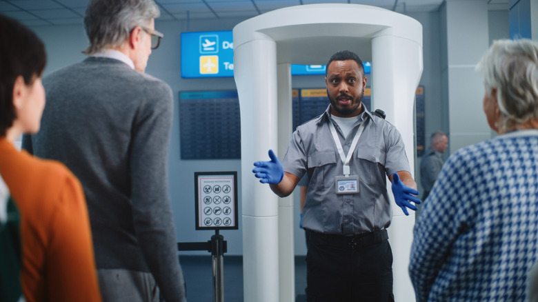 승객들이 공항의 보안 검색대에 접근하고 있습니다.