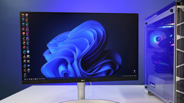 게임용 PC 옆 책상에 Windows 11 데스크톱이 표시되어 있는 LG 모니터