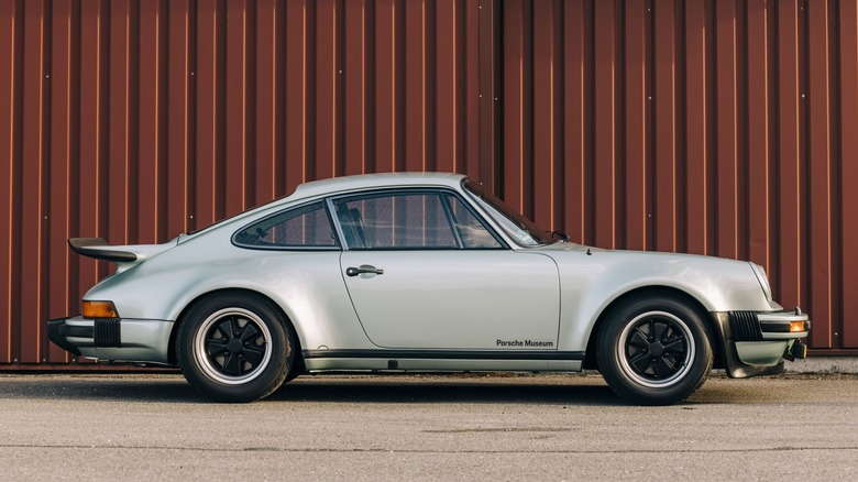 선적 컨테이너를 배경으로 활주로 위의 911 터보의 측면 모습