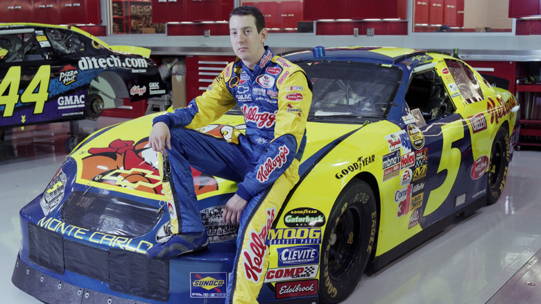 파란색과 금색 No. 5 Chevy 경주용 자동차 차고에 앉아 있는 Nascar 드라이버 Kyle Busch