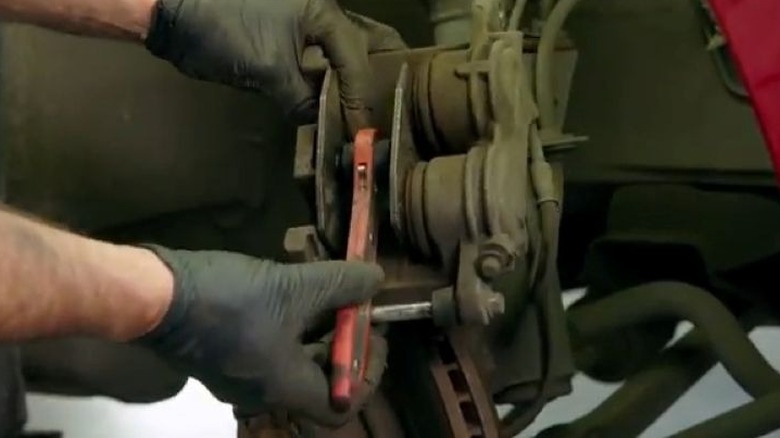 브레이크 캘리퍼에 패드 스프레더를 사용하는 사람