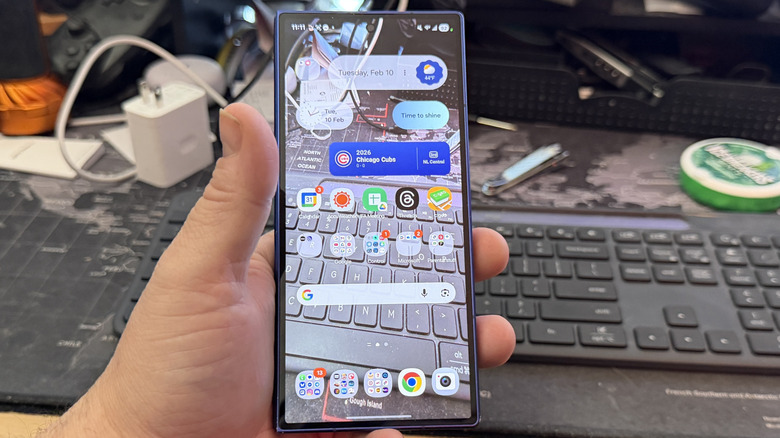 투명한 배경화면이 적용된 Android 휴대전화를 들고 있는 남자