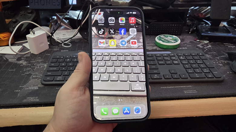 투명 배경화면이 적용된 아이폰을 들고 있는 남자