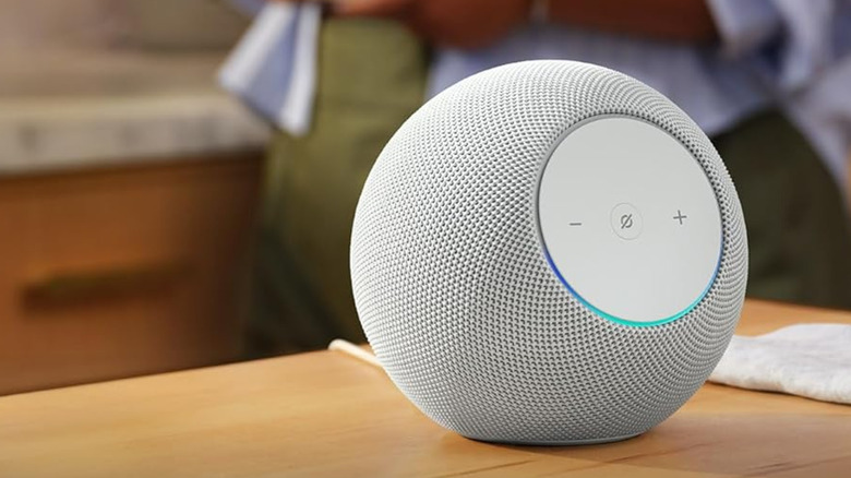 테이블 위에 있는 Amazon Echo Studio, 배경에 사람.