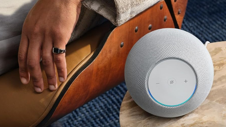 사람 근처 테이블 위에 놓인 Amazon Echo Studio.