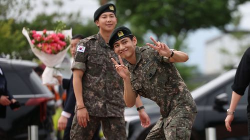 K팝 밴드 방탄소년단의 멤버 RM(왼쪽)과 뷔(오른쪽)가 2025년 6월 10일 대한민국 춘천에서 군 복무를 마치고 반응을 보이고 있다. 