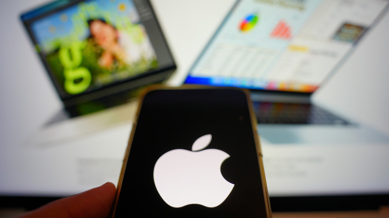 화면에 Apple 로고가 있는 iPhone 사진과 배경에 MacBook 사진