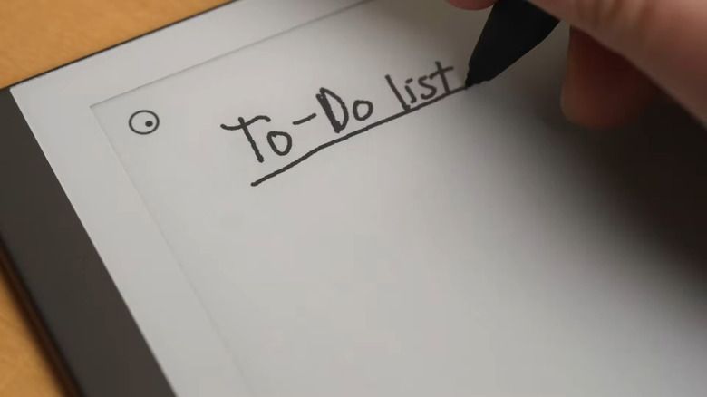 전자잉크 태블릿에 글을 쓰고 있는 사람