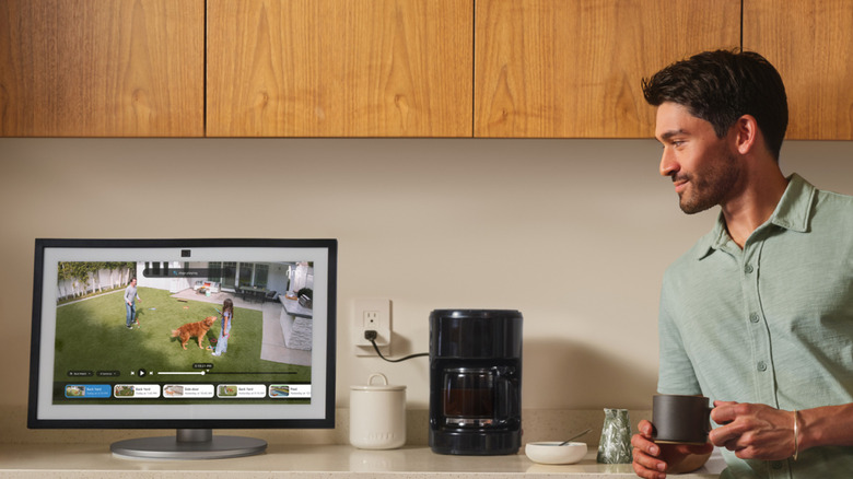 커피를 마시며 Echo 기기로 실시간 카메라 피드를 시청하는 사람