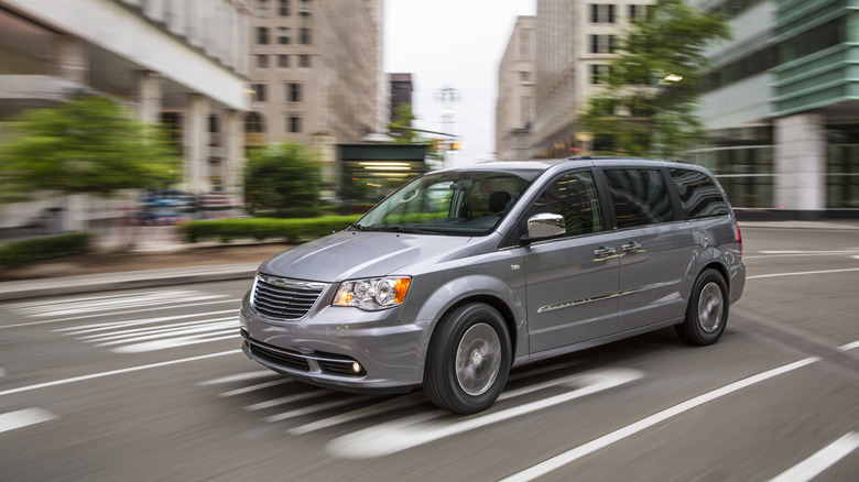 도시 도로를 주행하는 2014 Chrysler Town & Country 미니밴, 왼쪽 앞 3/4 뷰