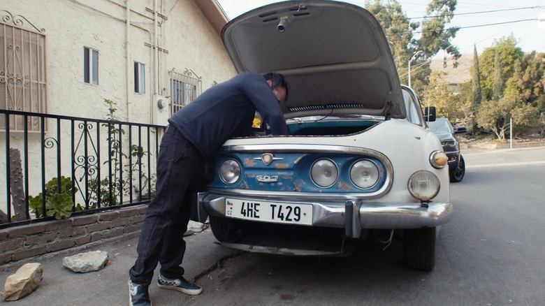 열린 스페어 타이어 접근 해치를 검사하는 사람이 있는 Tatra 603, 정면도