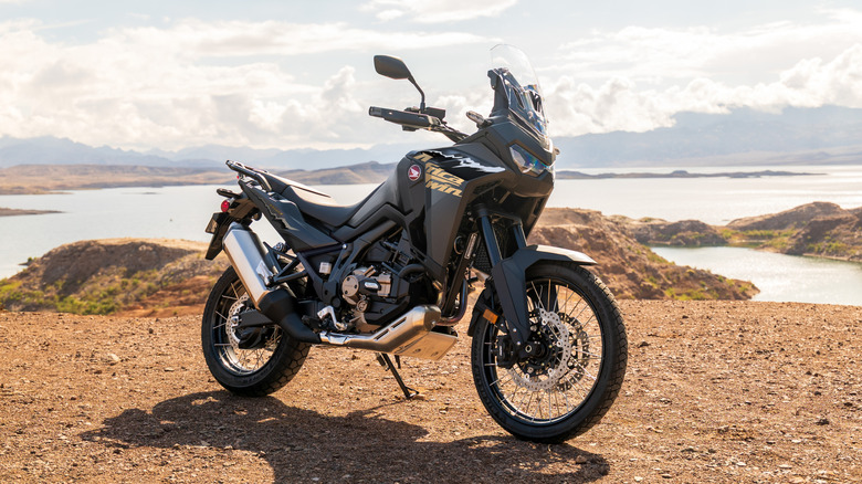 호수 근처 킥스탠드에 앉아 쉬고 있는 Honda Africa Twin
