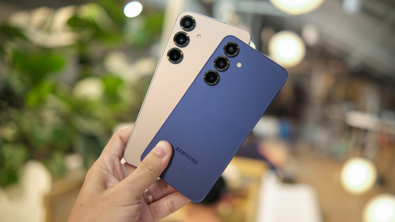 삼성 갤럭시 스마트폰 두 대를 들고 있는 사람