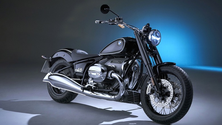 스튜디오 조명 아래 앉아 있는 검정색 BMW R 18 First Edition, 그 뒤에 짙은 파란색 빛이 납니다.