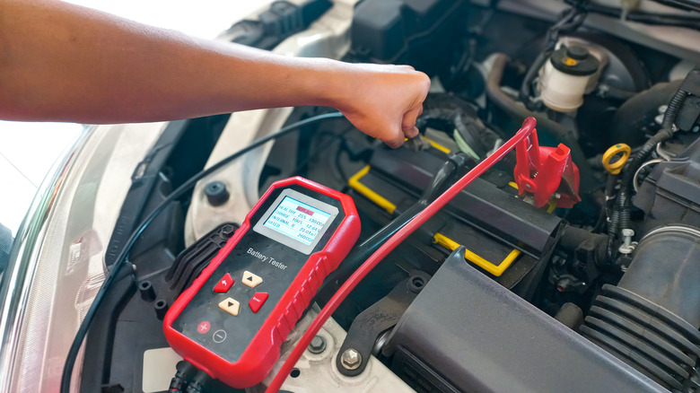 자동차 배터리를 테스트하는 정비공