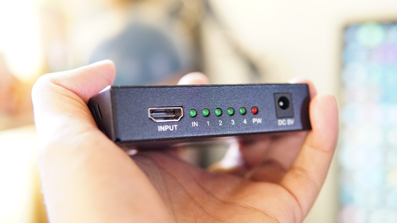 사람의 손에 있는 HDMI 분배기