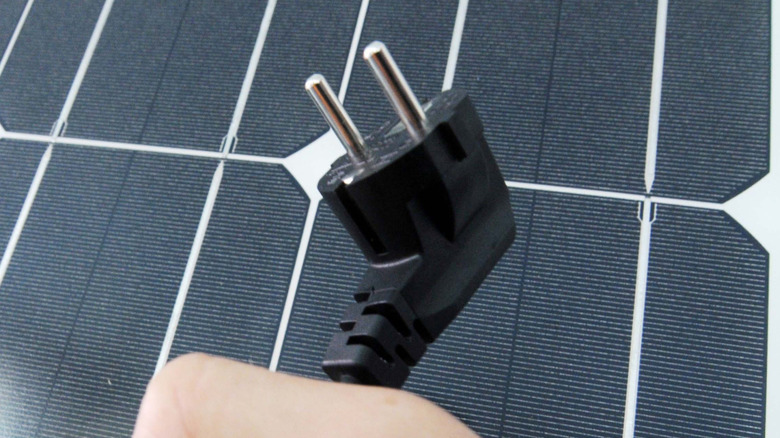태양광 패널 앞에 세워져 있는 두 갈래 플러그.
