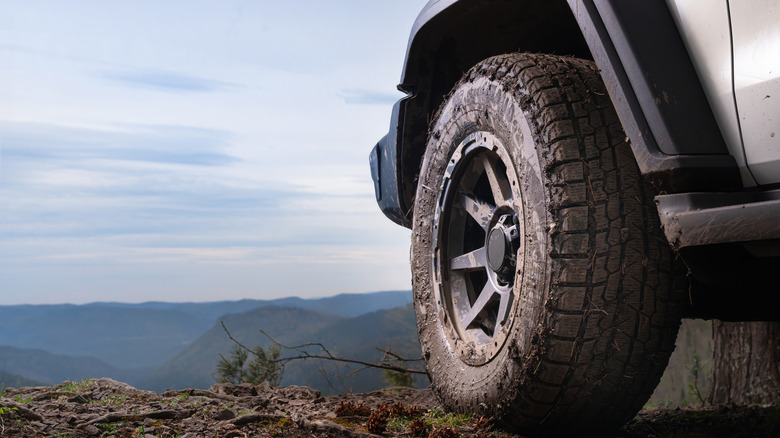 정체불명의 SUV에 있는 더러운 오프로드 타이어 클로즈업