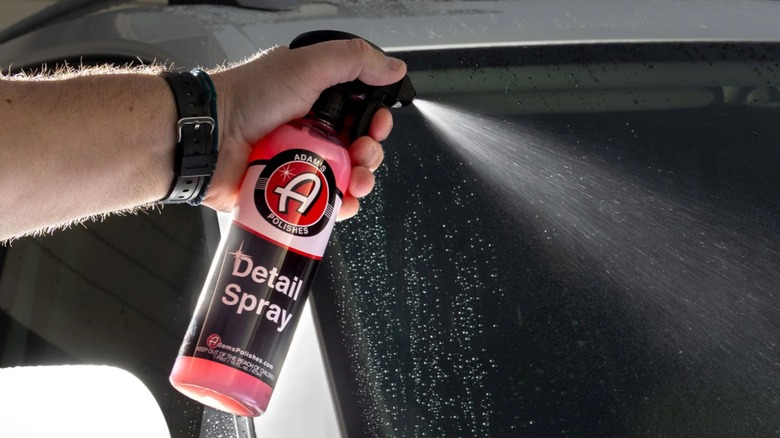 Adam's Polishes Detail 스프레이를 자동차에 뿌리고 있는 손