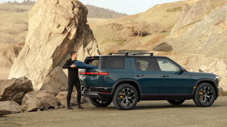 Rivian R2에서 서핑보드를 내리는 남자