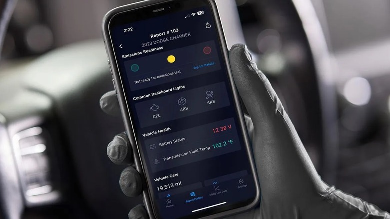 휴대전화로 차량 보고서를 읽고 있는 사람.