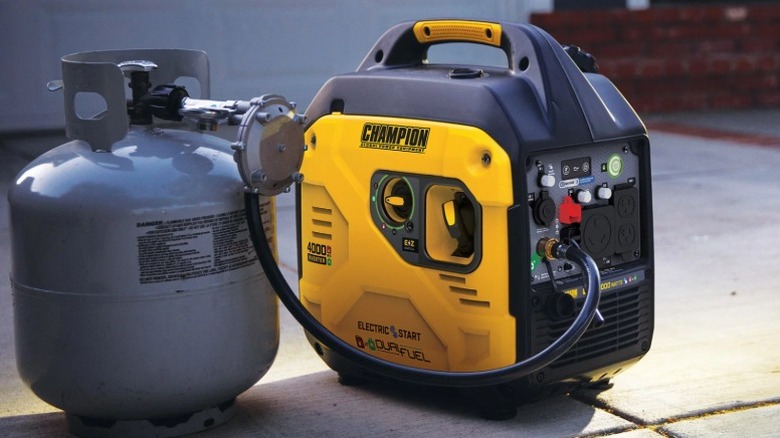 가솔린 용기 옆 지상에 있는 챔피언 이중 연료 인버터 발전기